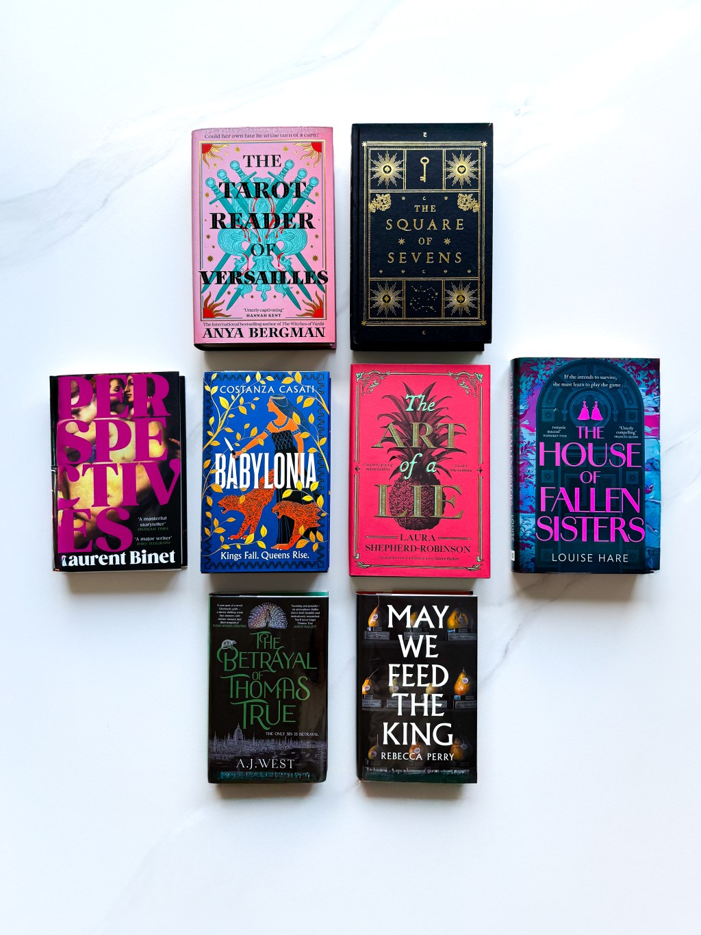 A photograph of all eight recommended books laid fat on a white marble background.